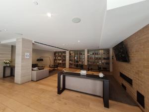 a large room with a brick wall and a desk at Brand New 2br2ba Caulfield Parkbalcony Poolgym in Melbourne