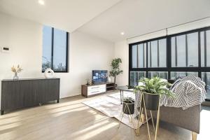 a living room with white walls and large windows at Stunning 2br Loft Maribyrnongfree Parkingbalcony in Maribyrnong