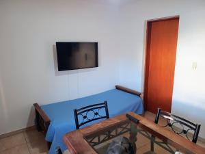 une chambre avec un lit et une télévision au mur dans l'établissement Departamento Amoblado 1H, à Río Cuarto
