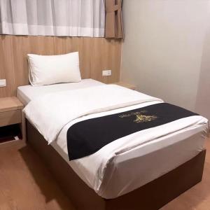 a bed with a black and white blanket on it at Maple Boutique Hotel in Melaka