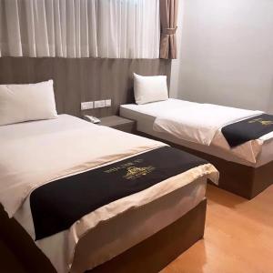two beds sitting next to each other in a room at Maple Boutique Hotel in Melaka