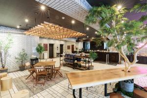 a restaurant with tables and chairs and a tree at Hotel Silk Tree Nagoya in Nagoya