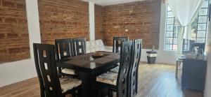 a dining room with a black table and chairs at Depto Accesible en Huachi Centro con Parking in Huauchinango