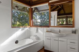 a bathroom with a tub and a sink and a window at Garden Burees in Byron Bay +88 photos
