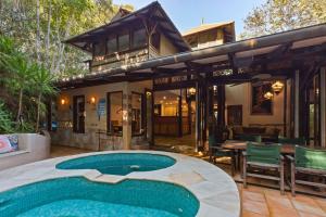 a house with a swimming pool in front of a house at Garden Burees in Byron Bay