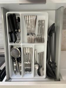 a white container filled with utensils in a drawer at Cape Bungalow - Newly Renovated, Fully Equipped, Minutes from the Beach! in Cape Coral
