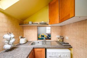 a small kitchen with a sink and a stove at Bright - Central - Sleeps 10 in Edinburgh