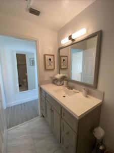 a bathroom with a sink and a mirror at Cape Bungalow - Newly Renovated, Fully Equipped, Minutes from the Beach! in Cape Coral +15 photos