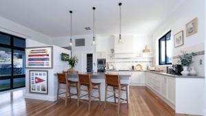 a kitchen with white cabinets and a table with chairs at Silos in East Kangaloon
