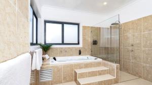 a bathroom with a tub and a glass shower at Silos in East Kangaloon