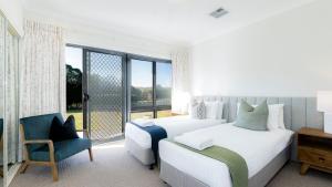 a bedroom with two beds and a chair and a window at Silos in East Kangaloon +31 photos