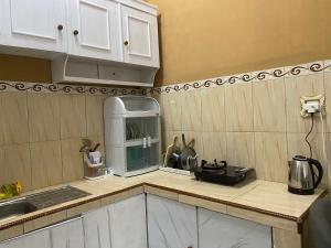 a kitchen with white cabinets and a counter top at Djogja Homestay in Piyungan +7 photos