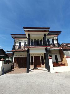 a large house with a balcony on top of it at Djogja Homestay in Piyungan