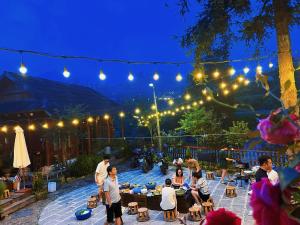 a group of people sitting around a patio at night at Homestay số 91-Suối Hồ Sa Pa in Sa Pa