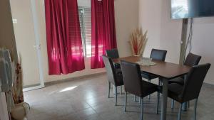 a dining room with a table and chairs and red curtains at Departamentos Centro in Belén