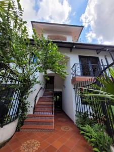 Una casa blanca con escaleras al frente. en Casa Enayati - Entire 4 Bedroom Home Coco Del Mar, en Panamá