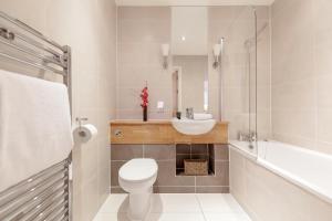 y baño con aseo, lavabo y ducha. en Roomspace Serviced Apartments - Marquis Court en Epsom