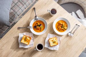 a table with three plates of food and two bowls of soup at Tokyu Stay Kamata - Tokyo Haneda in Tokyo