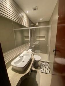 a bathroom with a sink and a toilet at Pousada La Acolhida in Cabo Frio