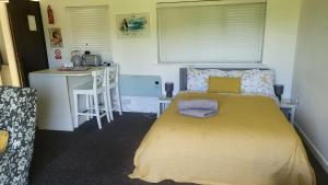 a small bedroom with a bed and a desk at The Piggery - Corfe Mullen in Corfe Mullen