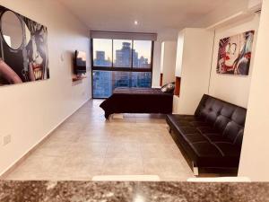 a living room with a couch and a large window at Center Suites Ideal parejas in La Plata