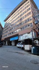 a large building with a car parked in front of it at Studio Condo near Burnham in Baguio +1 photo