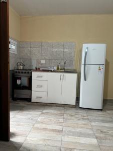 a kitchen with a white refrigerator and a stove at Residencia Las Americas in Garupá