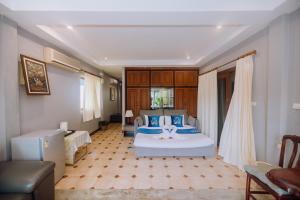 a bedroom with a large bed in a room at Monaburi Boutique Resort in Rawai Beach