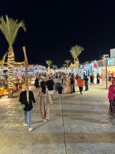a group of people walking on a beach at night at Casa Lydia in Naama Bay in Sharm El Sheikh