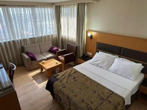 a hotel room with a bed and a couch at Pınar Elite Hotel in Adana