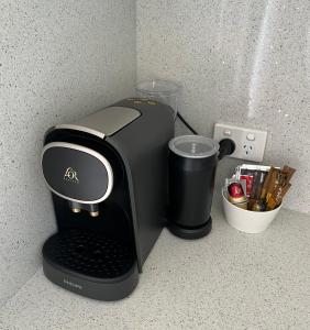 a black coffee maker on a counter with a cup at Beach Studio with Ocean View in Gnarabup