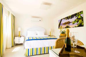a bedroom with a bed and a table with a bottle of wine at Hotel Solar do Arco in Cabo Frio