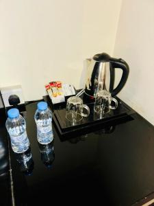 a tea kettle and two water bottles on a table at درة فلسطين للشقق المخدومة - جدة - حي الفيحاء - تصنيف مرافق الايواء السياحي اقتصادي Durrat Palestine Serviced Apartments - Jeddah - Al Fayhaa District - Economic Tourist Accommodation Facilities Classification in Jeddah