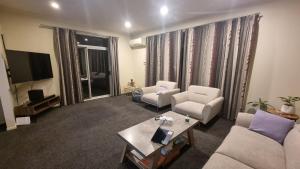 a living room with two couches and a tv at Home stay - Double Bed at Churton Park in Wellington