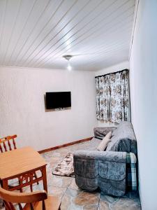 カンポス・ド・ジョルドンにあるCasa para temporadaのソファとテレビのあるリビングルーム