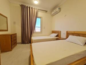 a bedroom with two beds and a window at Star house apartments in Hurghada