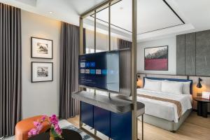 a hotel room with a bed and a flat screen tv at Swiss-Belinn Malang in Malang