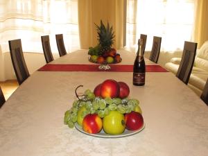 a plate of fruit on a table with a bottle of wine at Apartments near Lesser Town in Prague