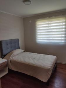 a small bedroom with a bed and a window at Casa en sector nor-oriente de Talca in Talca