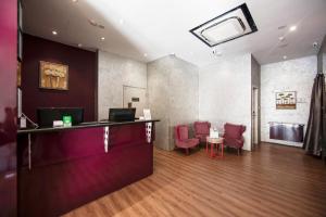 a waiting room with red chairs and a counter at Fragrance Hotel - Rose in Singapore