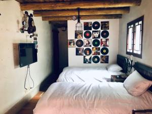 una camera da letto con letto e dischi appesi al muro di Red Tomato B&B a Jinsha