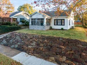 a house with a stone wall in front of it at Walk To Cherry Street,pets, Hot Tub By Hvnlyhomes in Tulsa