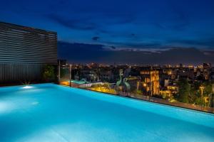 a swimming pool on the roof of a building at night at Anatole Hotel Hanoi in Hanoi