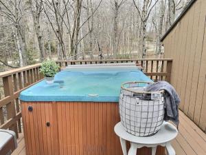 a hot tub on the deck of a house at HappyCub- AC, Hot Tub, Fire Pit, Game Room! in Killington