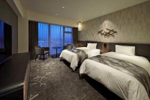 a hotel room with two beds and a window at Hotel Vischio Kyoto by GRANVIA in Kyoto