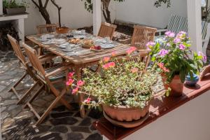 un tavolo in legno con sedie e fiori su un patio di I Ginepri B&B a Portoscuso