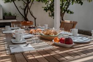 un tavolo in legno con un piatto di frutta sopra di I Ginepri B&B a Portoscuso