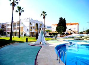 un resort con piscina e palme di APCOSTAS - Habitat Playa Romana ad Alcossebre