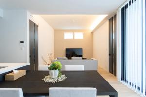 a living room with a table and a couch at Mova Villa Koshi Misawa south in Kikutomi