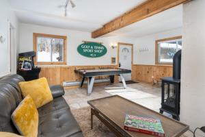 a living room with a ping pong table at HappyCub- AC, Hot Tub, Fire Pit, Game Room! in Killington